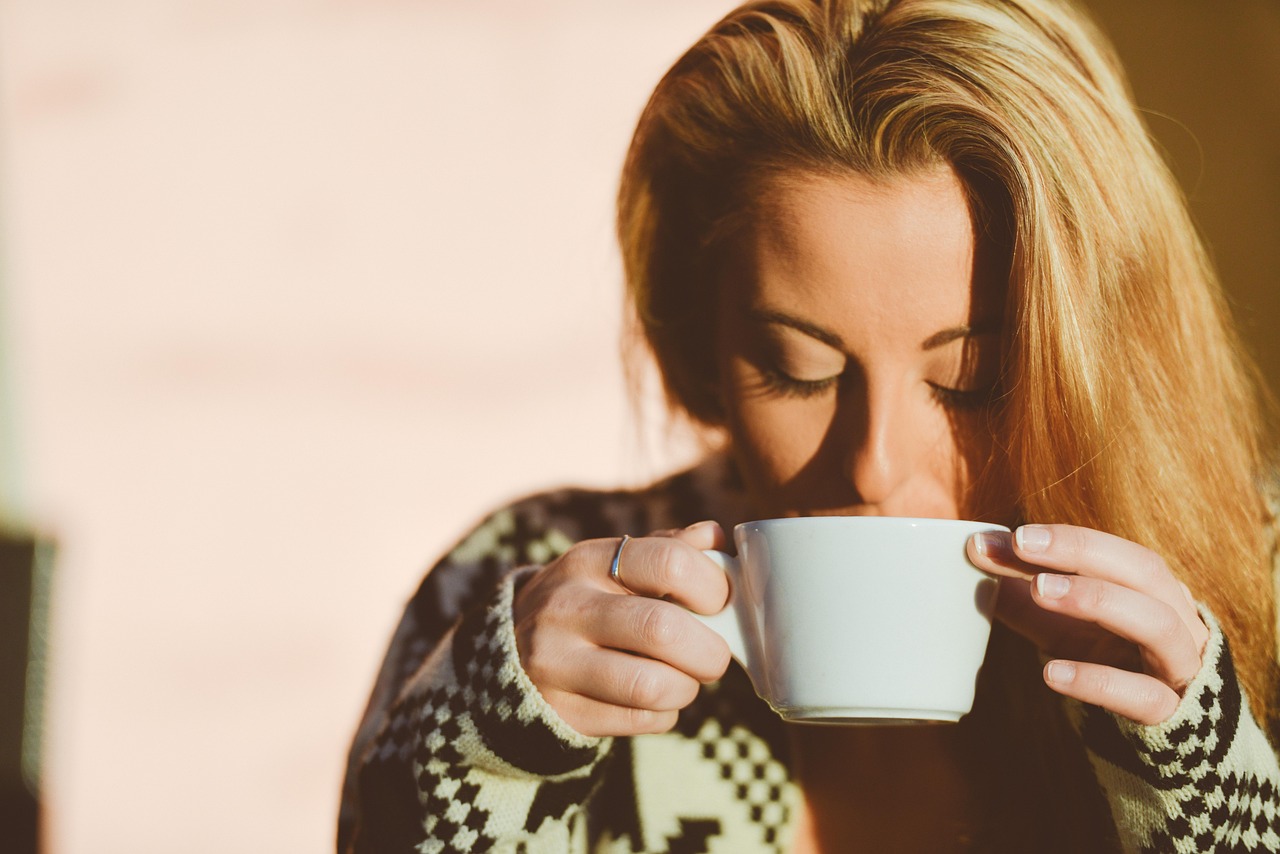 Tazza di caffè fumante su un tavolo, simbolo di energia e relax contro stress e ansia.