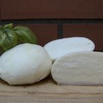 Mozzarella fresca con etichette di origine e qualità, simbolo di autenticità del prodotto.
