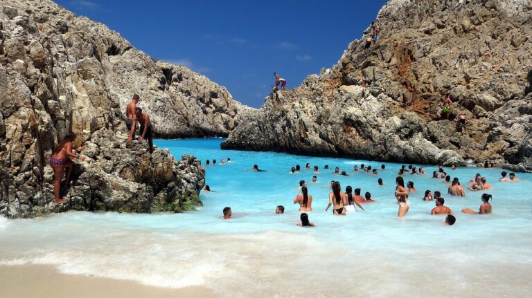 Piscina naturale in Sardegna, circondata da rocce e vegetazione, con acque cristalline e cielo azzurro.