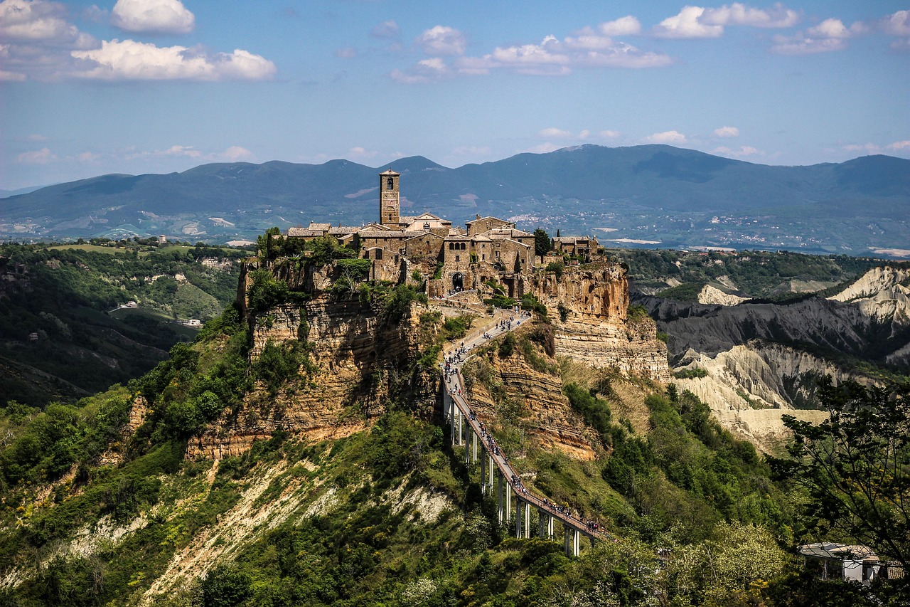 Panorama suggestivo di un borgo umbro, circondato da colline verdi e cielo sereno, evocando un'atmosfera senza tempo.