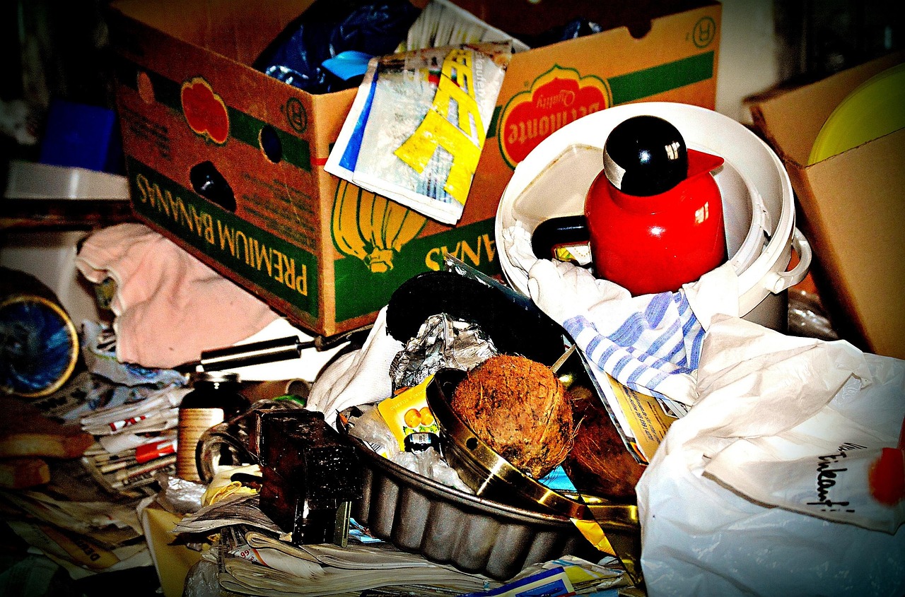 Immagine di avanzi di cibo in un contenitore, con un segno di avviso "buttare" per indicare la scadenza.