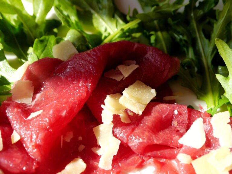 Bresaola appesa a essiccare, simbolo della tradizione gastronomica italiana.