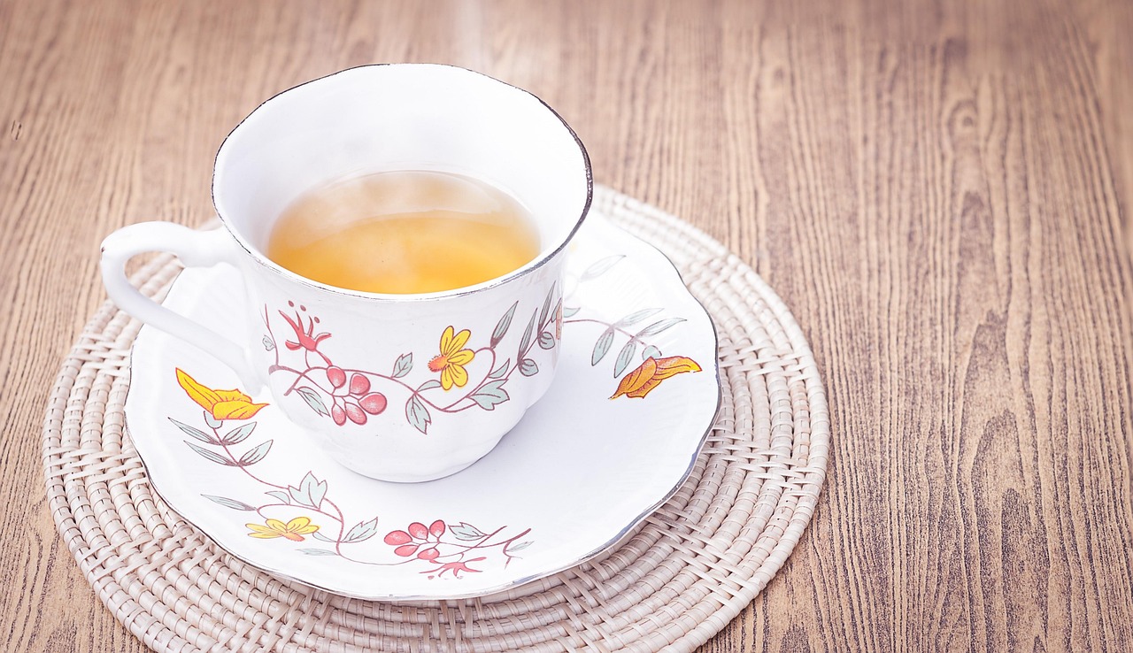 Tazza di tè fumante, ideale per sciogliere i grassi addominali, su un tavolo al mattino.