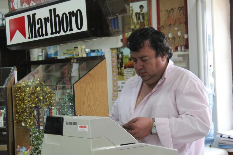 Uomo al banco di un tabacchi mentre spiega trucchi per vincere ai Gratta e Vinci.