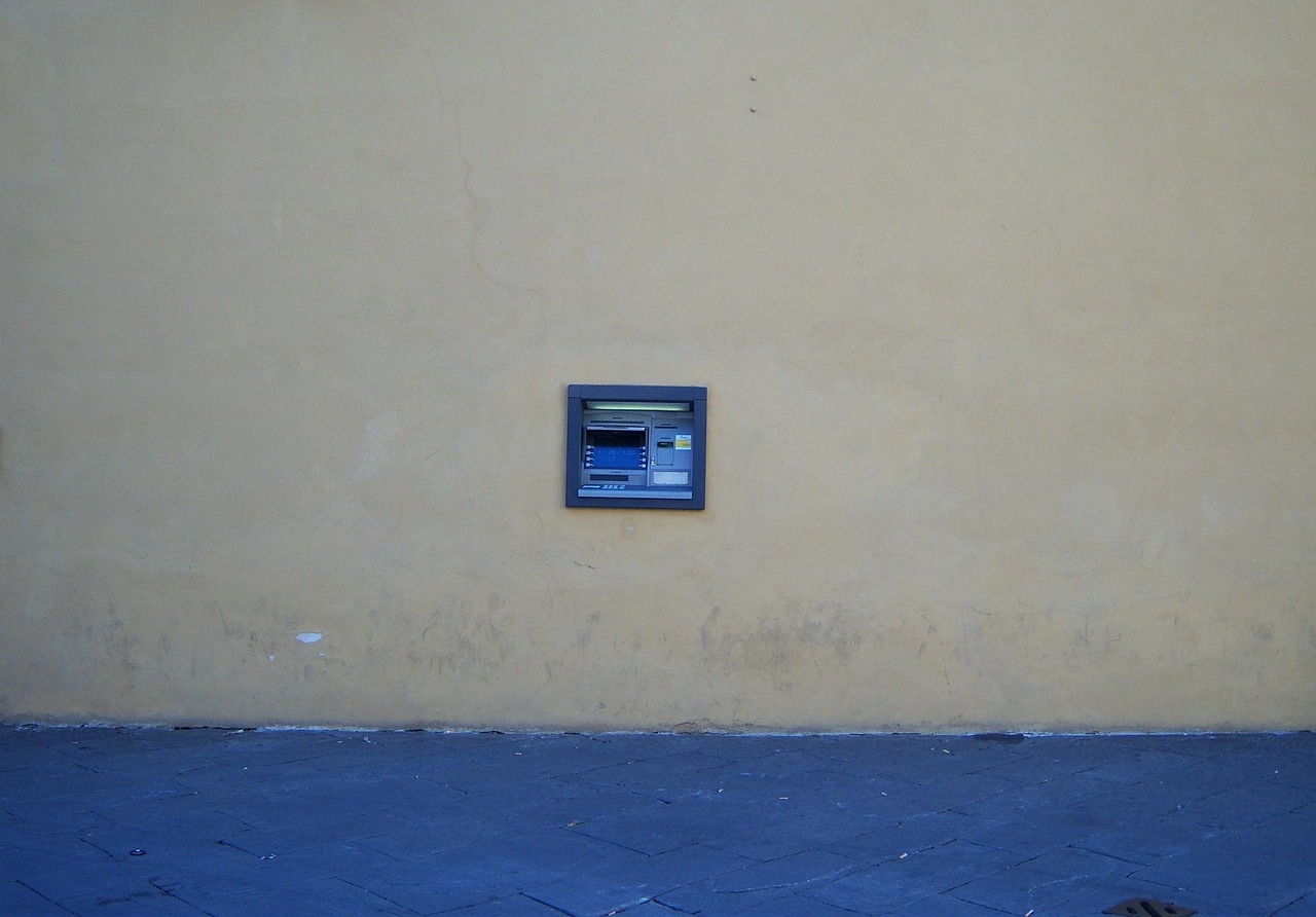 Immagine di un bancomat con avviso di allerta e istruzioni per il prelievo.