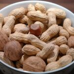 Noci su un tavolo con testo informativo su come ridurre il colesterolo cattivo.