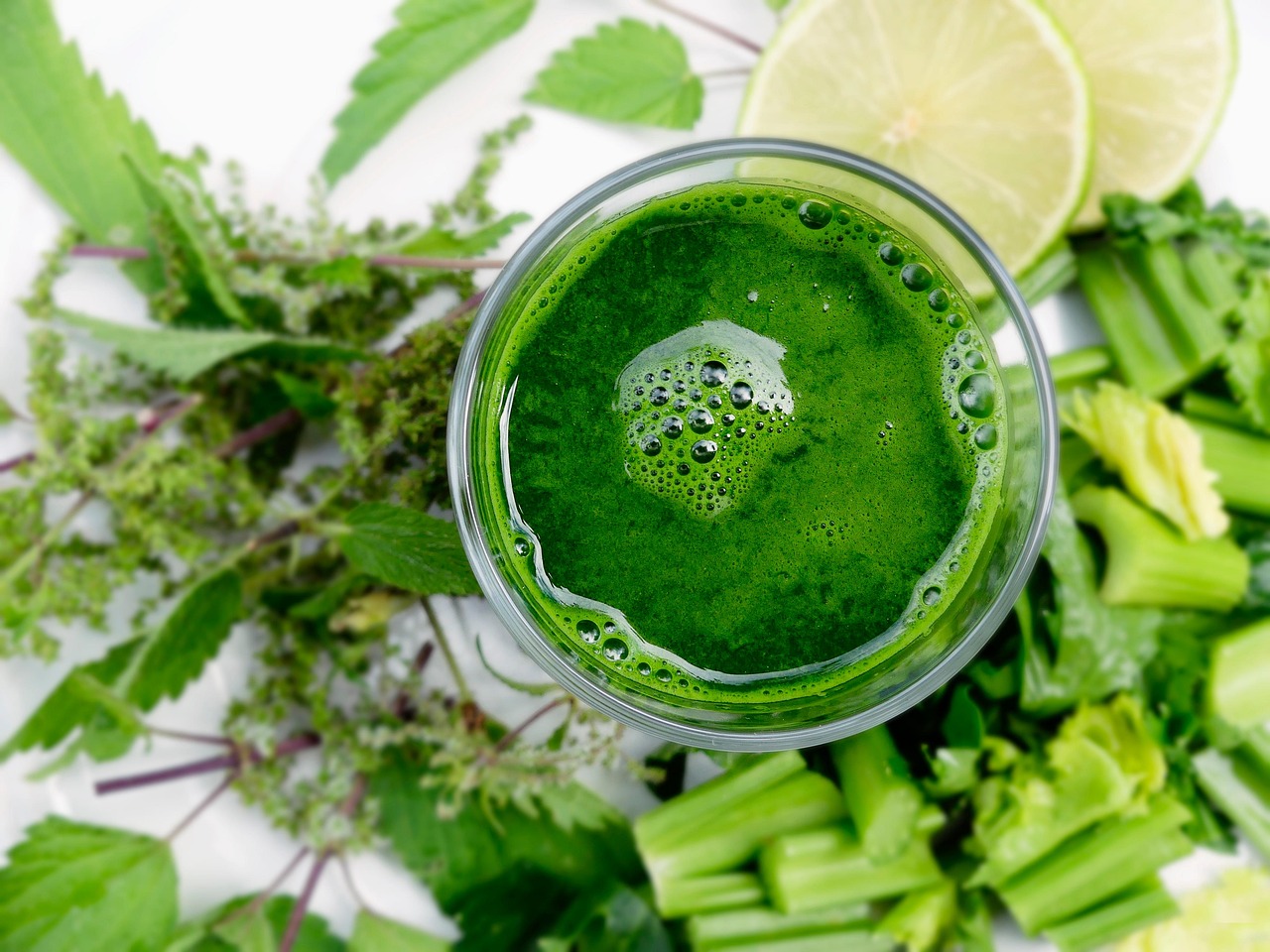 Bevanda verde in un bicchiere, ingredienti freschi e naturali per depurare il fegato e migliorare la digestione.