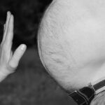 Donna che pratica esercizi di yoga per sgonfiare la pancia prima di dormire.